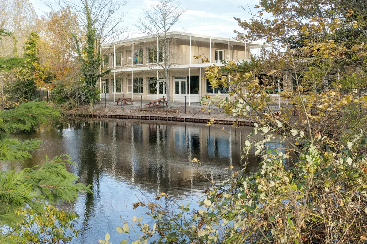 Het schoolgebouw aan het water, gezien vanaf de overkant