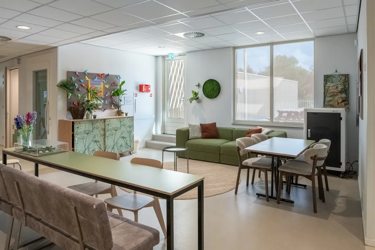 Het leerplein van groep 7 en 8 met werktafels en een zithoek