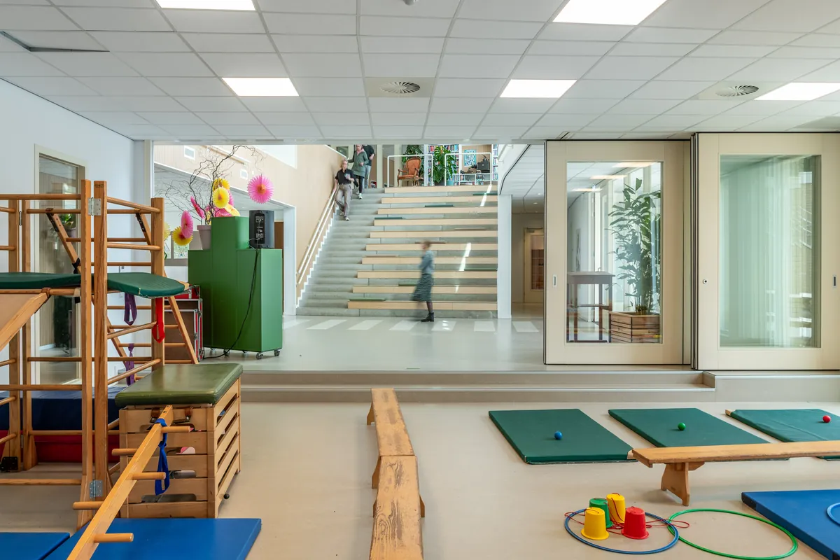 Het speellokaal voor kleuters en peuters, met zicht op de centrale hal en de tribunetrap