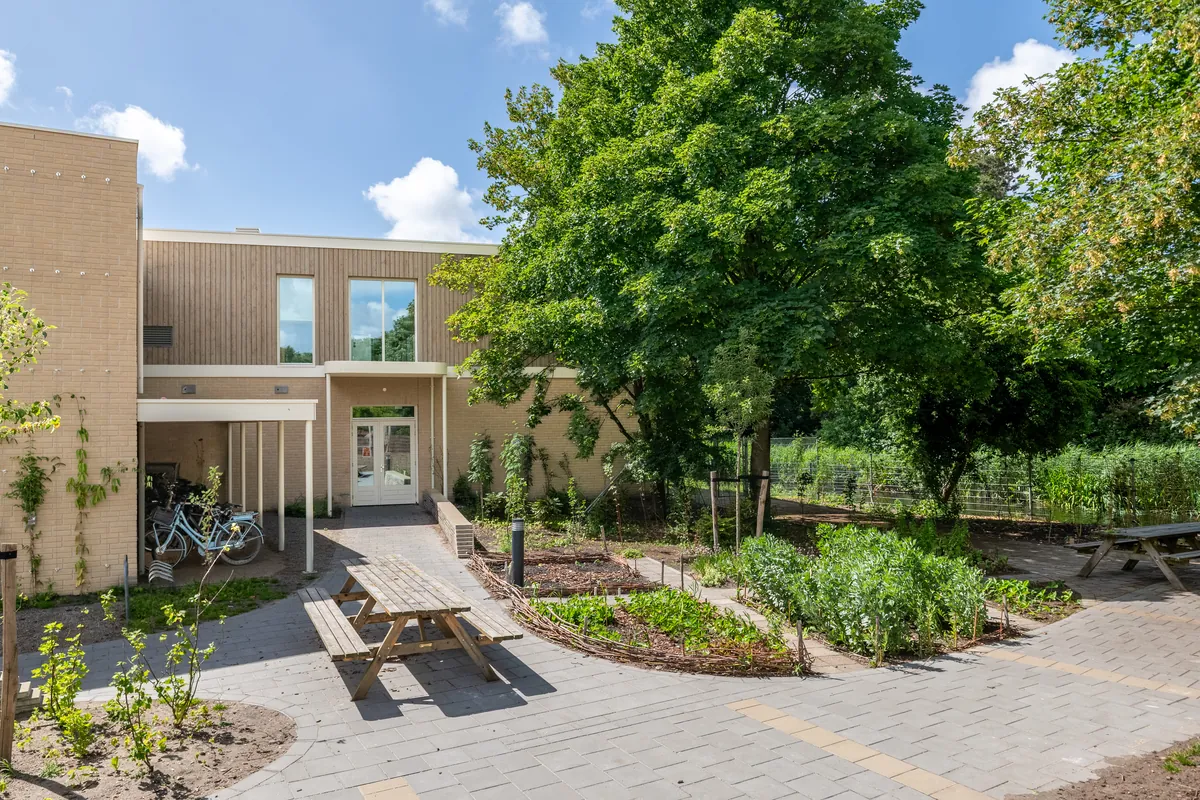 Tuin met picknicktafel bij een lokaal op de begane grond